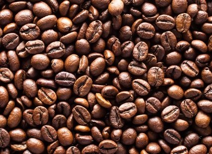 A close photograph of dark roasted coffee beans, from the brand's own ingredient image set